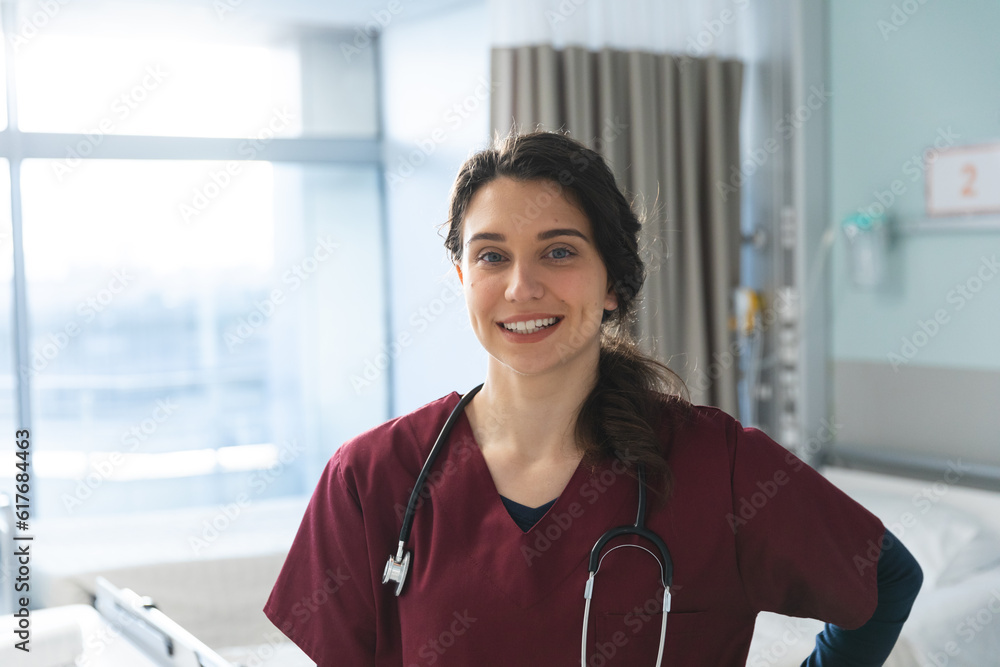 Portrait of happy caucasian female doctor with brown hair, wearing red scrubs and stethoscope Portrait of happy caucasian female doctor with brown hair, wearing red scrubs and stethoscope