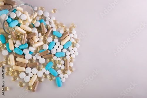 Medical pills scattered on a pink surface