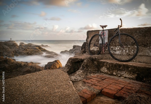 Old bike leaning against a seawall on the Gold Coast, Qld, Australia. © Roger Harrison/Wirestock Creators