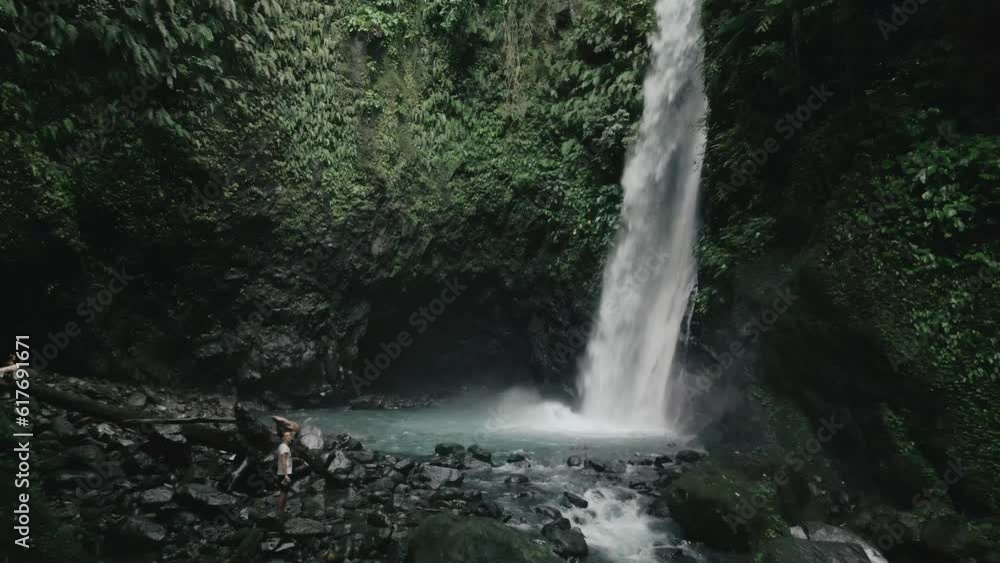 Aerial video of a waterfall between rocky mountains covered with tropical trees Aerial video of a waterfall between rocky mountains covered with tropical trees