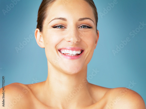 Smile, cosmetics and portrait of happy woman with dermatology, skincare and makeup on blue background. Happiness, skin care and wellness, face of model with beauty and facial glow on studio backdrop.
