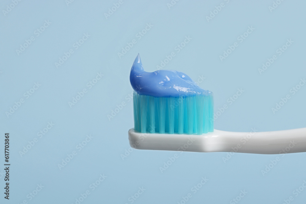 Plastic toothbrush with paste on light blue background, closeup Plastic toothbrush with paste on light blue background, closeup