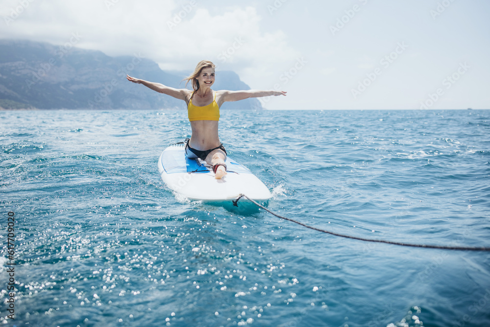 A woman practices yoga at the sea. SUP sports