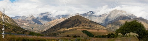 Tableau sur toile Breathtaking mountain landscape with a grassy field in the foreground
