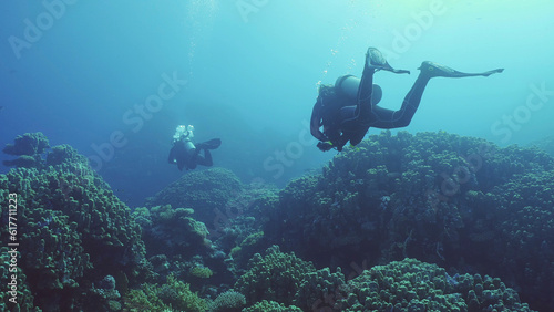 Group of scuba divers swims in the deep next to coral reef in bright sunny day, , Backlighting (Contre-jour), Back view, Red sea, Safaga, Egypt © Andriy Nekrasov