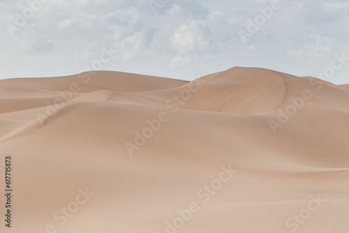 Beautiful view of a deserted area with sand dunes on a cloudy sky background