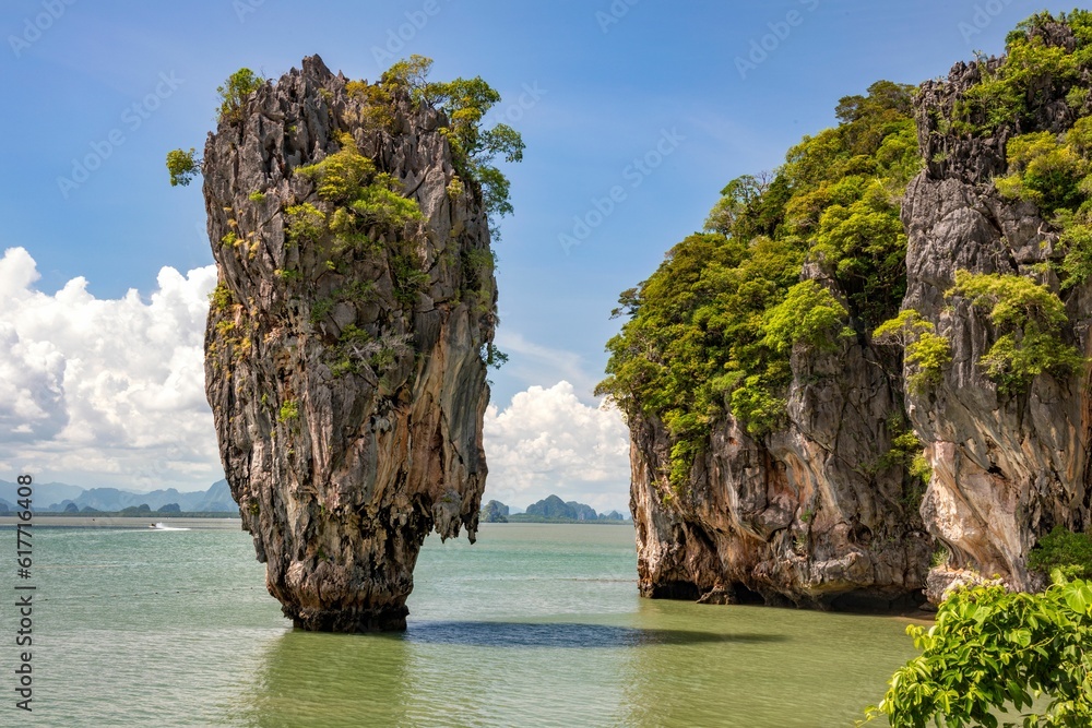 the island with three very tall rocks is in the middle of water