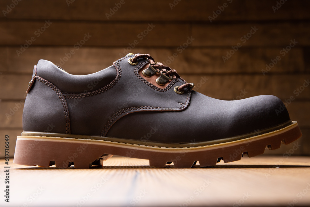 Stylish men's casual work boots for everyday walking in nature and the city on a wooden background stylish concept Stylish men's casual work boots for everyday walking in nature and the city on a wooden background stylish concept