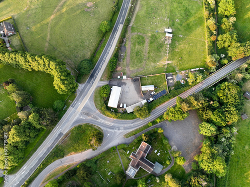 Aerial picture looking down directly above a small church and farm near a road junction