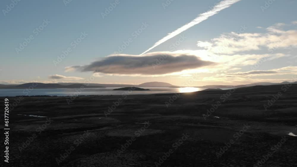 Aerial of the golden sunrise shining over the lake and wide valley behind the morning clouds Aerial of the golden sunrise shining over the lake and wide valley behind the morning clouds