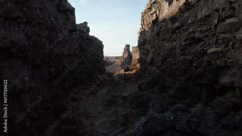 Aerial of people walking on the pathway surrounded by big cliffs in Iceland Aerial of people walking on the pathway surrounded by big cliffs in Iceland