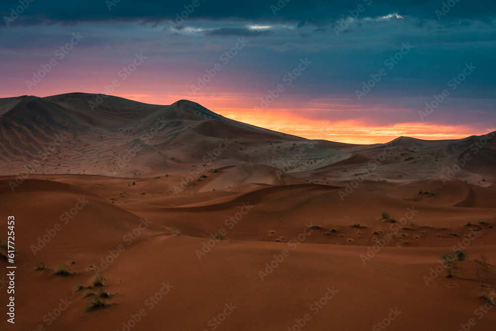 Sunset in Merzouga in the Sahara Desert, Morocco. Merzouga is a small village in southeastern Morocco, about 35km (22 miles) southeast of Rissani, about 55km (34 miles) from Erfoud and about 50km (31 