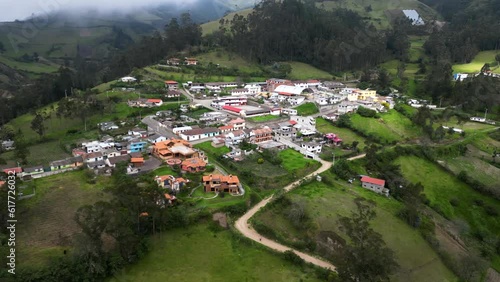 Aerial video of the small town surrounded by mountains covered with trees, Isinlivi, Ecuador
