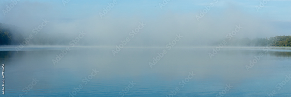 Morning fog on the lake on a summer day