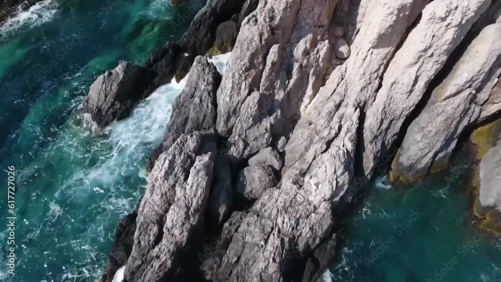 Aerial drone shot of ocean waves rolling and crashing into rock Aerial drone shot of ocean waves rolling and crashing into rock