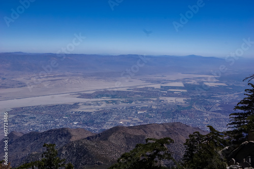 Scenic aerial vistas of Coachella Valley seen from the top of Palm Springs tramway station in Mt. San Jacinto State Park, California, USA. View on mountain landscape and canyons. Trees in foreground