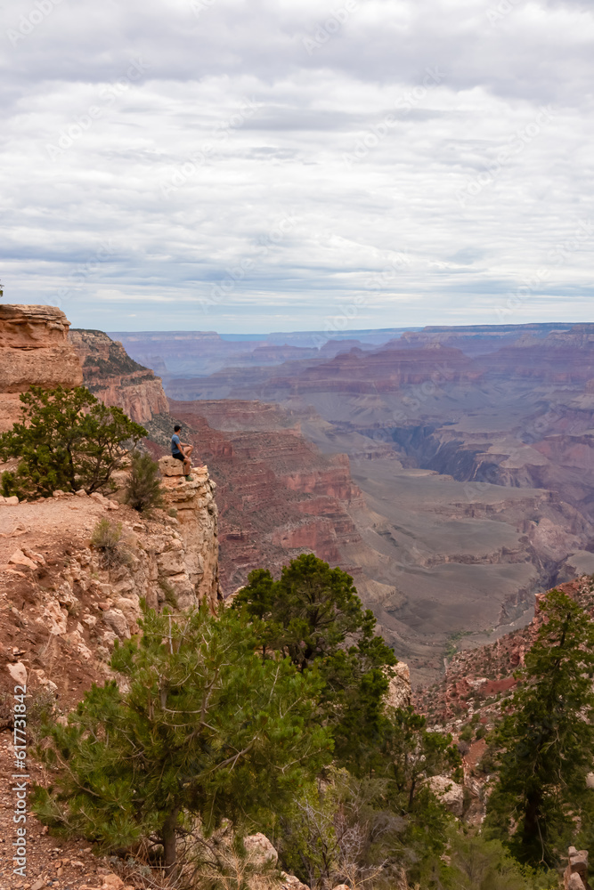 Man with scenic view from Skeleton Point on South Kaibab hiking trail at South Rim, Grand Canyon National Park, Arizona, USA. Colorado River weaving through valleys and rugged terrain. O Neill Butte