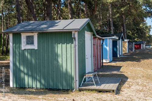 Colorful beach huts, little wooden houses on the beach, glamping tourism © Bohdan