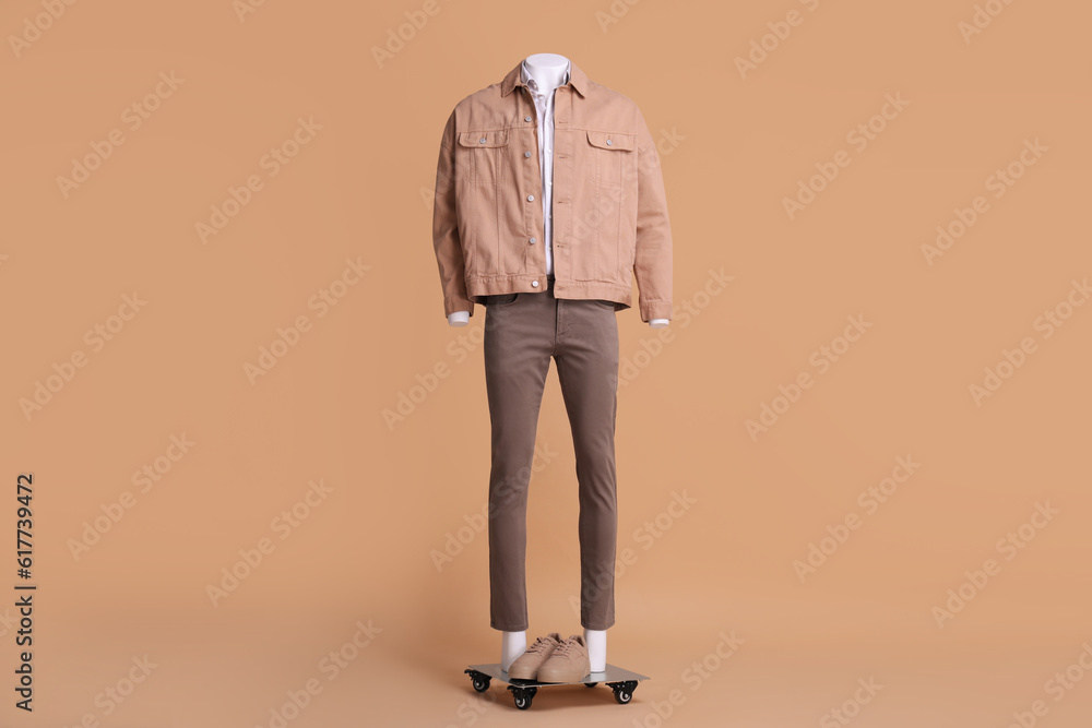 Fototapeta premium Male mannequin with sneakers dressed in white shirt, jacket and pants on beige background. Stylish outfit