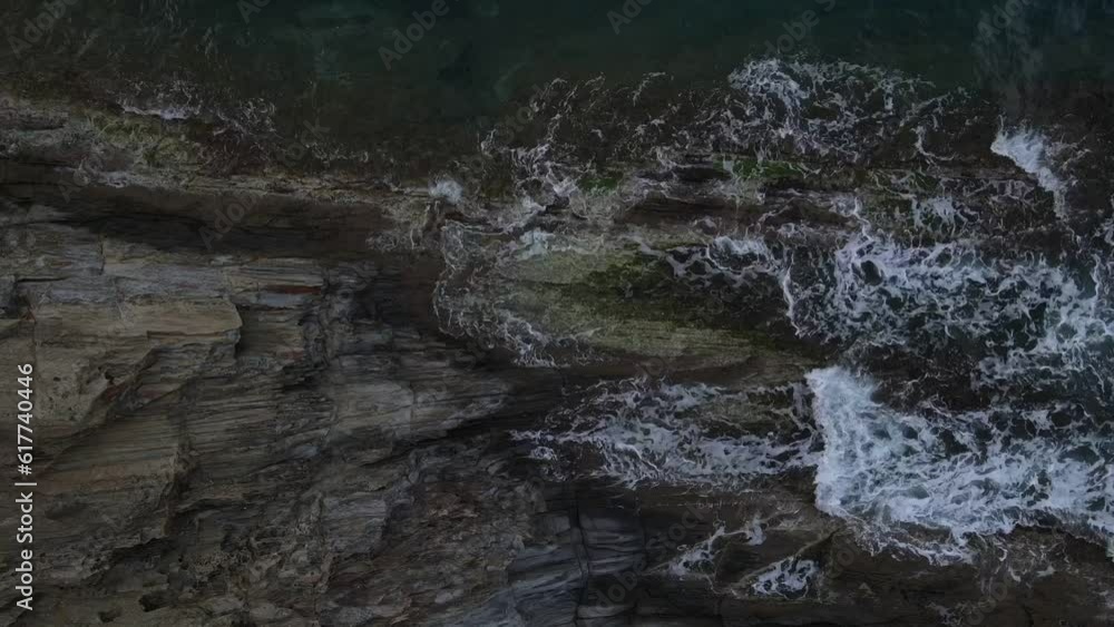 Top down aerial view of waves crashing onto a rock in nature near Cadaques Catalonia Spain Top down aerial view of waves crashing onto a rock in nature near Cadaques Catalonia Spain
