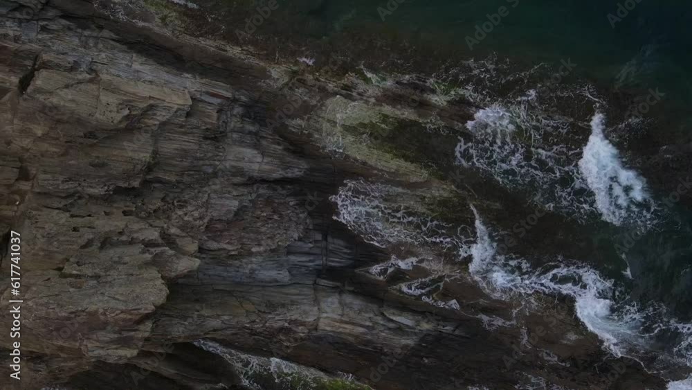 Top down aerial view of waves crashing onto a rock in nature near Cadaques Catalonia Spain Top down aerial view of waves crashing onto a rock in nature near Cadaques Catalonia Spain