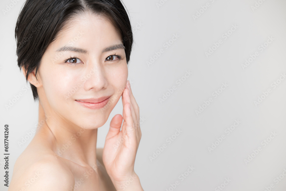 Asian woman with a beautiful smile and clear skin like a bare skin, looking at the camera, copy space on the right, close-up Asian woman with a beautiful smile and clear skin like a bare skin, looking at the camera, copy space on the right, close-up