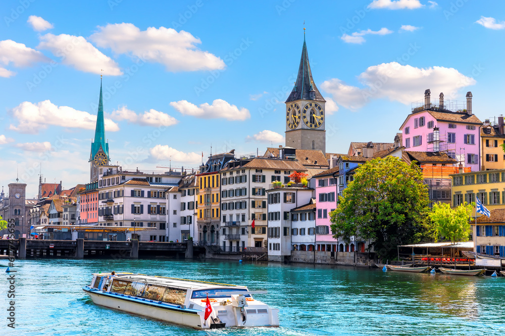 Ship is sailing by St. Peter's church and Fraum nster abbey, the two most popular places of visit in Zurich, Switzerland