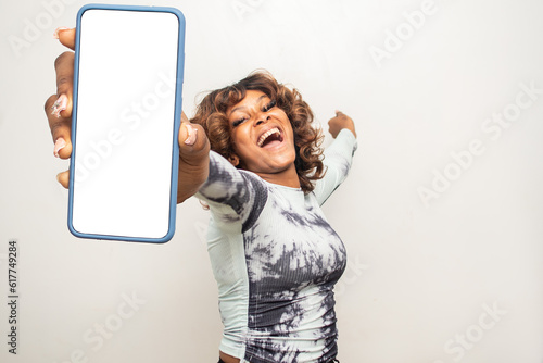 young african woman showing her phone screen excitedly