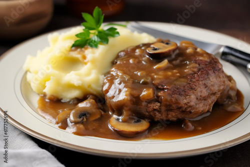 Delicious home cooked Salisbury steak with thick luscious brown mushroom gravy served with mashed potatoes on a plate. Traditional American cuisine dish specialty for family dinner holiday celebration