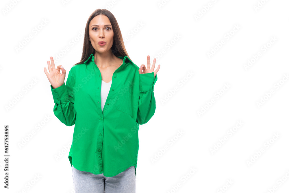 pretty slim european brunette woman with long hair and brown eyes dressed in casual green shirt is meditating pretty slim european brunette woman with long hair and brown eyes dressed in casual green shirt is meditating