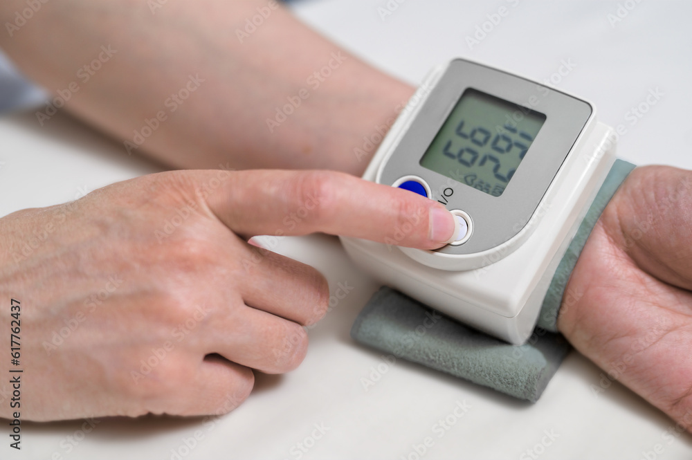 Measuring blood pressure at home. modern digital blood pressure monitor on a female wrist - obrazy, fototapety, plakaty 