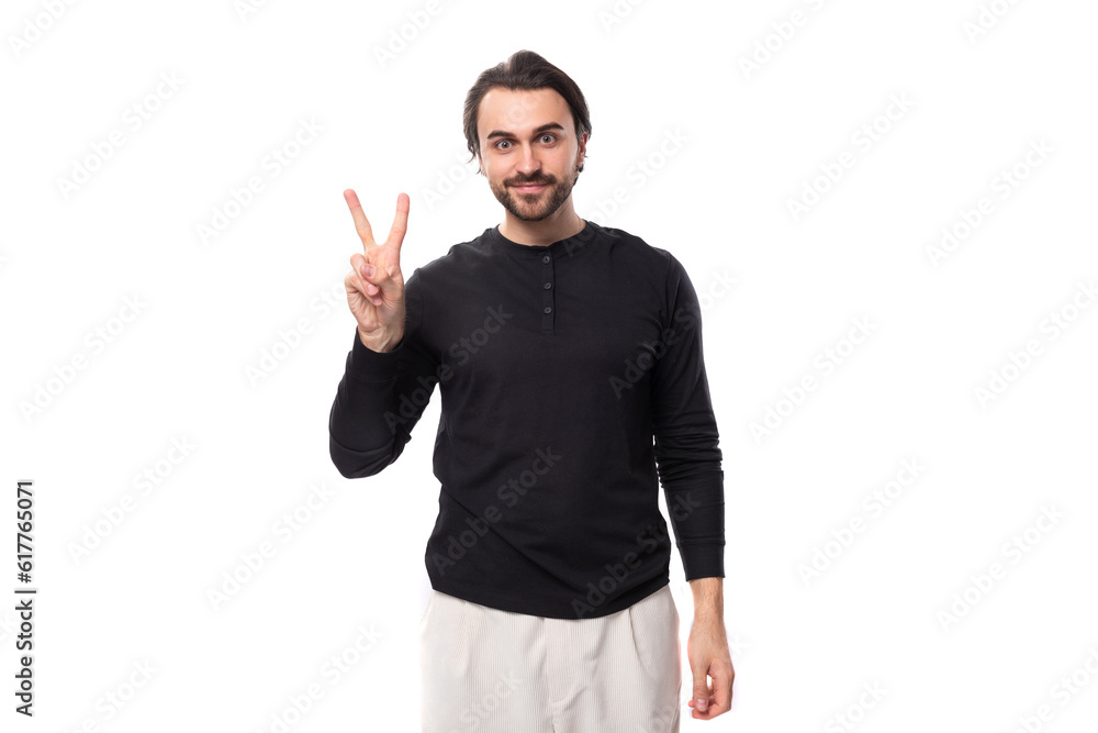 young brutal handsome brunette european man in a black sweater on an isolated white background young brutal handsome brunette european man in a black sweater on an isolated white background