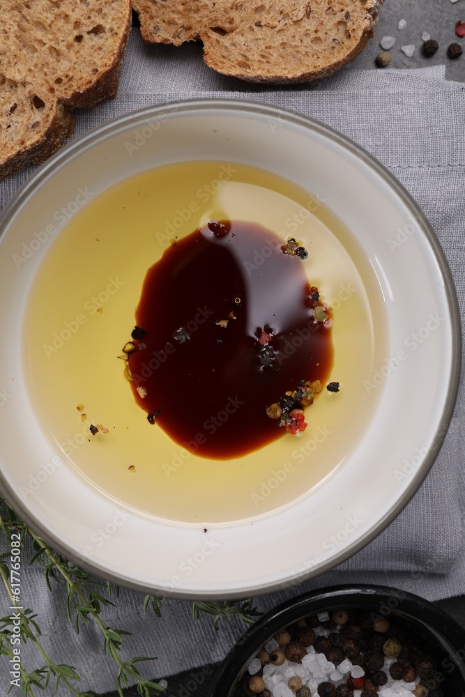Bowl of organic balsamic vinegar with oil, spices and bread slices on grey table, flat lay Bowl of organic balsamic vinegar with oil, spices and bread slices on grey table, flat lay