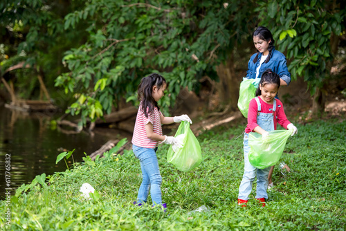 Group student Charity and recycle plastic for environment.  People asia girl  and boy collecting garbage and plastic on the nature river to dumped 