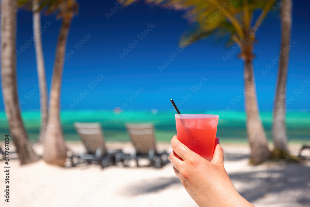 Exotic island beach with palm trees on the Caribbean Sea shore and summer refreshing cocktail pina colada