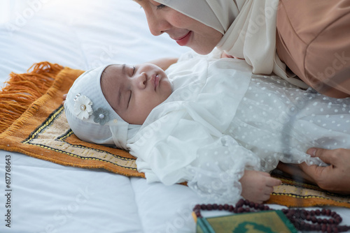 Muslim mom wears hijab looking her newborn baby face to face, happy loving family concept, Mother's Day photo