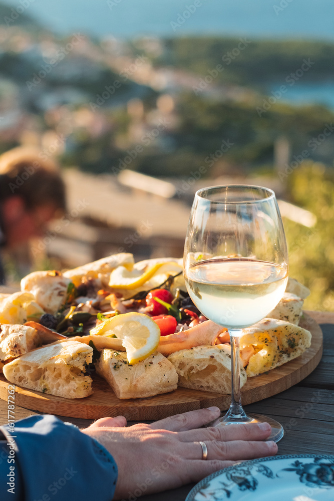 Luxury seafood board and a glass of wine with amazing sea view of Kvarner bay and Lošinj archipelago of Croatia islands