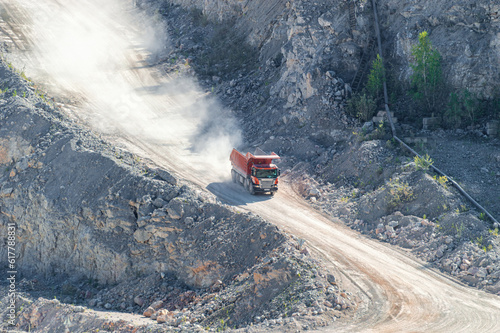Heavy Dump Truck Rides on a Industrial Terraces of the Open Pit Mineral Mine