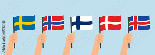Hands holding flags of Scandinavian countries (Sweden, Norway, Finland, Denmark, Iceland). Vector illustration in flat style on blue background.