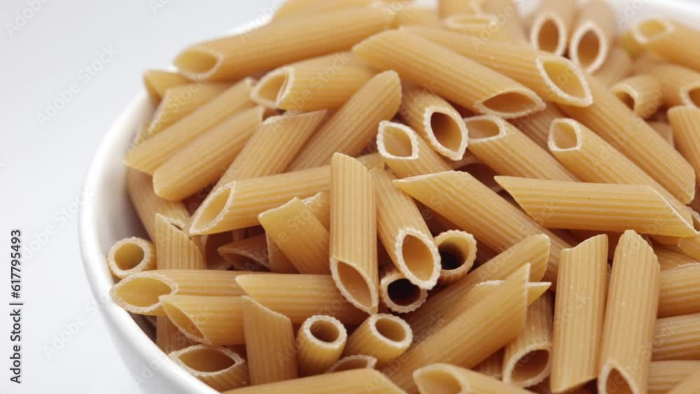 Penne Rigate. Raw Italian Pasta In A White Bowl. Rotating. 4k, 60 FPS. Penne Rigate. Raw Italian Pasta In A White Bowl. Rotating. 4k, 60 FPS.