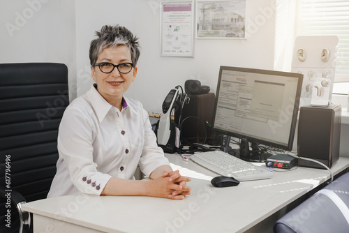 Otolaryngologist at modern mediccal center. Portrait of audiologist who assess disorders of hearing. Ear model on the table. Copy sapce photo