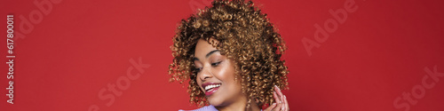 Young black woman with afro curls smiling and posing at camera
