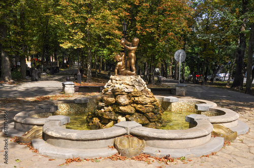 Old beautiful fountain Bathing children in the city park on a sunny day