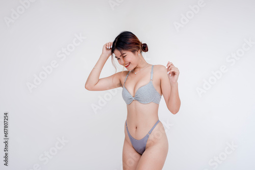 Tablou pe pânză A sultry southeast asian woman wearing only gray bra and panties dancing and grooving