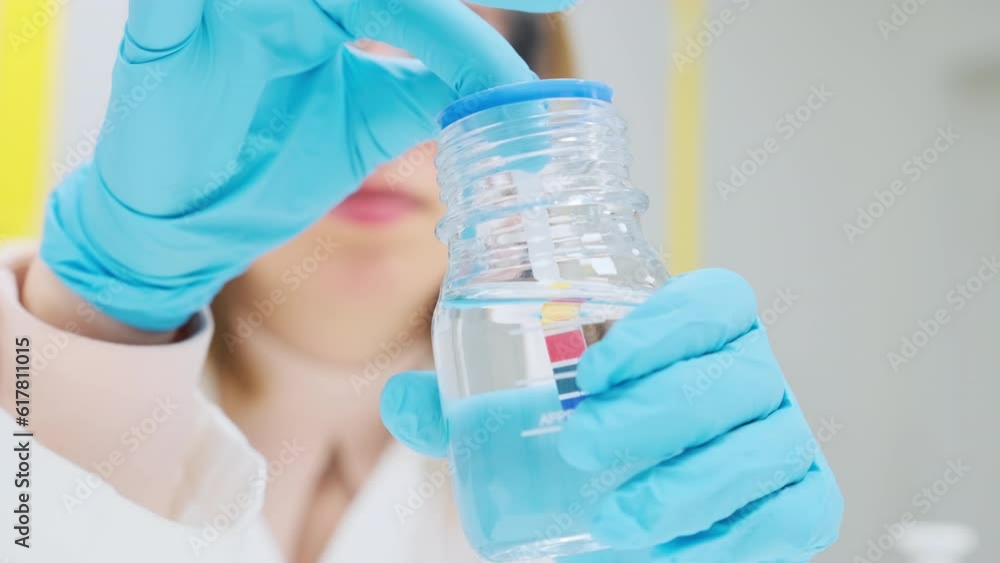 Measurement of pH of the solution using indicator paper. Scientist in the laboratory. Measurement of pH of the solution using indicator paper. Scientist in the laboratory.