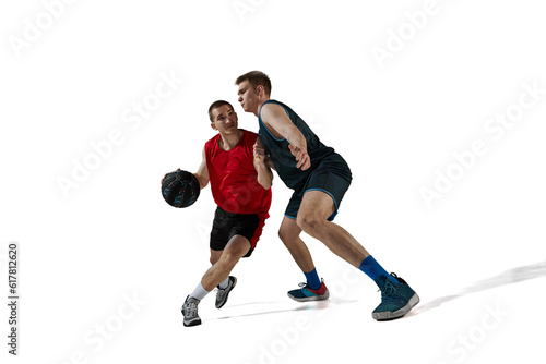 Two professional basketball players in motion during game, playing with ball isolated against white background. Concept of sport, action and motion, health, game, hobby, sportswear, ad