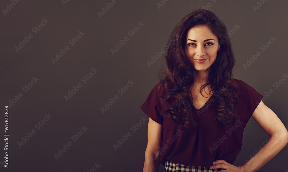 Beautiful natural makeup smiling woman with long curly volume brown healthy hair style looking happy. Closeup portrait on grey background. Beautiful natural makeup smiling woman with long curly volume brown healthy hair style looking happy. Closeup portrait on grey background.