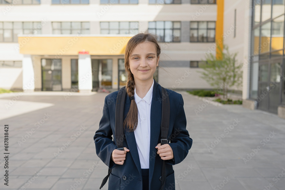 Confident young teenage schoolgirl standing with backpack Confident young teenage schoolgirl standing with backpack