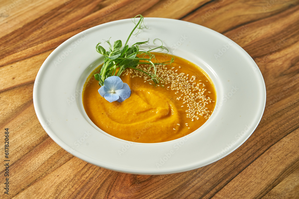Vegetarian carrot ginger or pumpkin cream soup in a plate Vegetarian carrot ginger or pumpkin cream soup in a plate