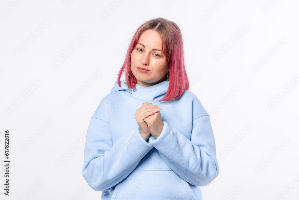 Pretty woman say thank you, express gratitude, looking cute and flattered, holding hands on heart. Lovely female model with pink hair in a blue hoodie standing over white background Pretty woman say thank you, express gratitude, looking cute and flattered, holding hands on heart. Lovely female model with pink hair in a blue hoodie standing over white background